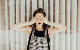 Devojka drži ruke preko očiju