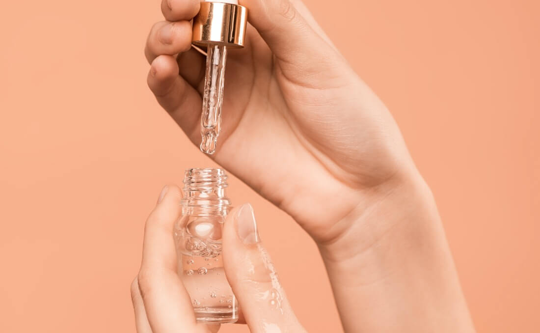 Niacinamid serum sa pipetom u rukama žene