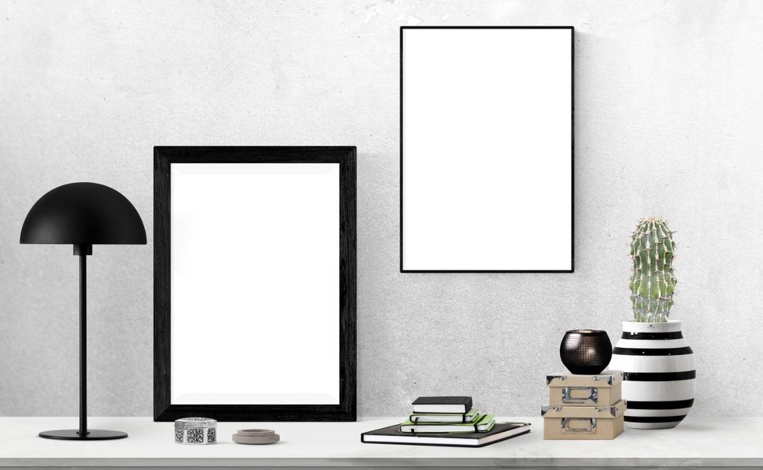 Radni sto na kojem su rokovnici, lampa, biljka i drudge stvari.