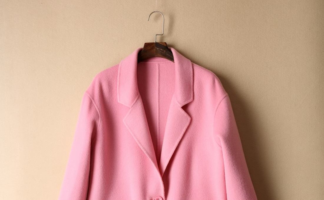 Roze kaput na vešalici.
