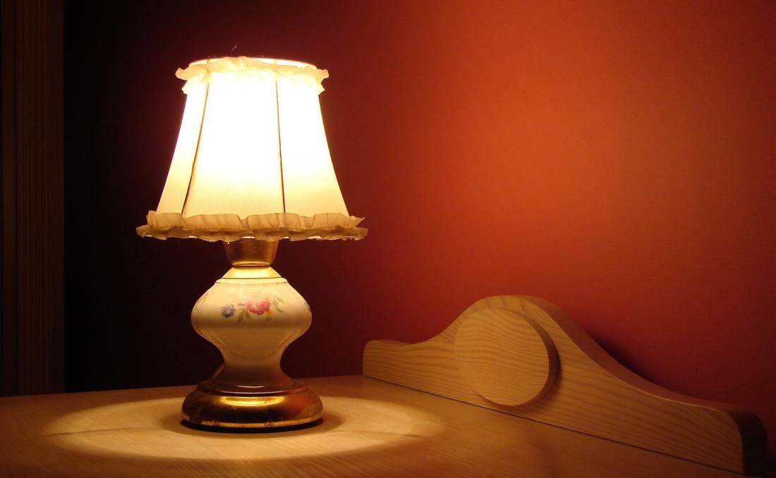 Lampa koja je upaljena na komodi.