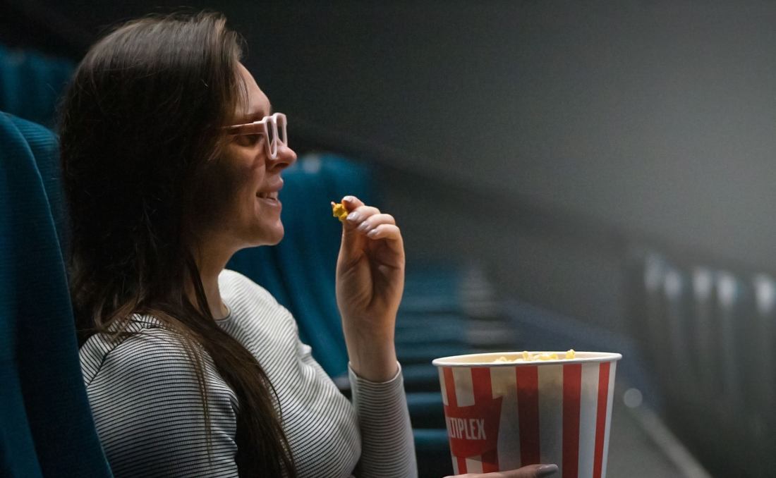Žena u bioskopu sa kokicama.