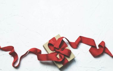 Poklon za auto sa crvenom mašnom.