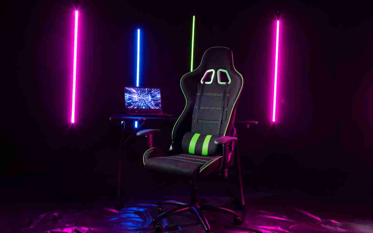 Gejmerski kutak sa neon osvetljenjem, laptopom i ergonomskom gejmerskom stolicom.