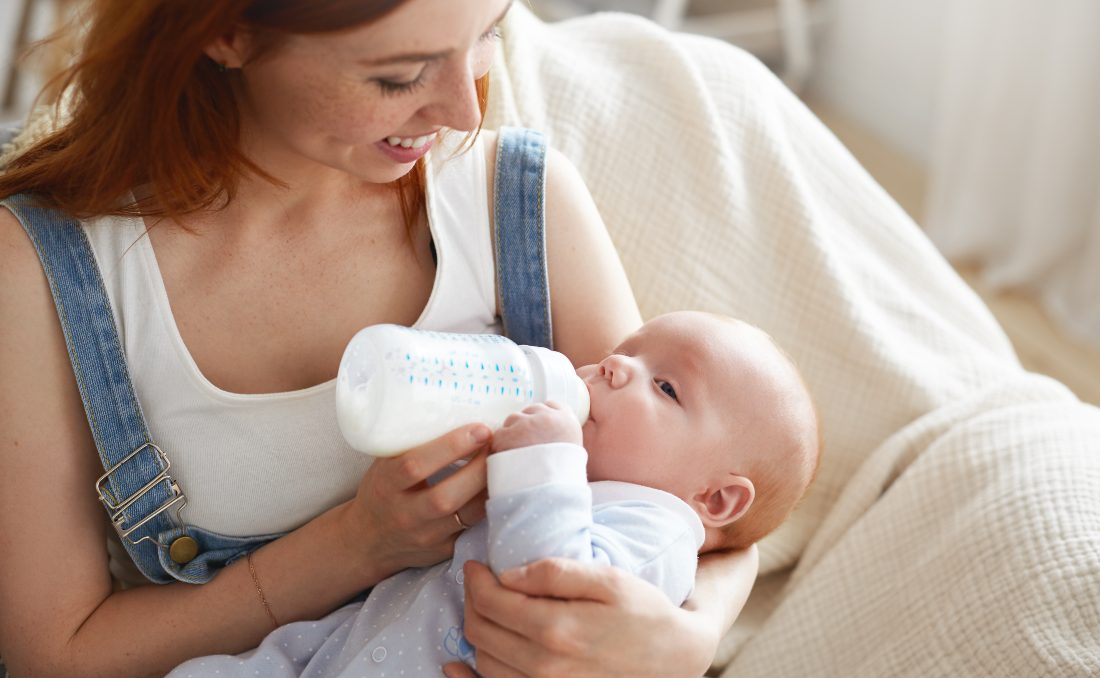 Majka hrani bebu mlečnom formulom iz flašice.