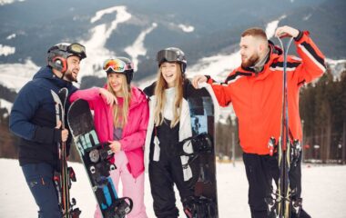 Prijatelji na skijanju u zimskim odelima na planini.