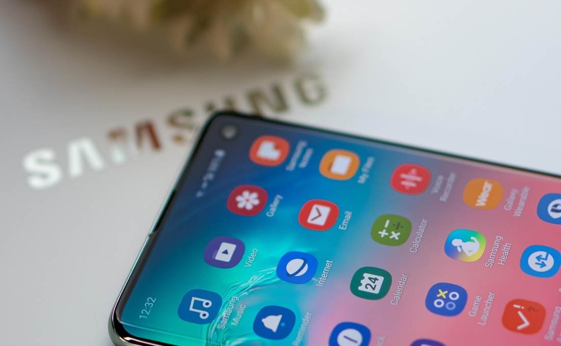 Samsung Galaxy telefon na stolu pored cveća.