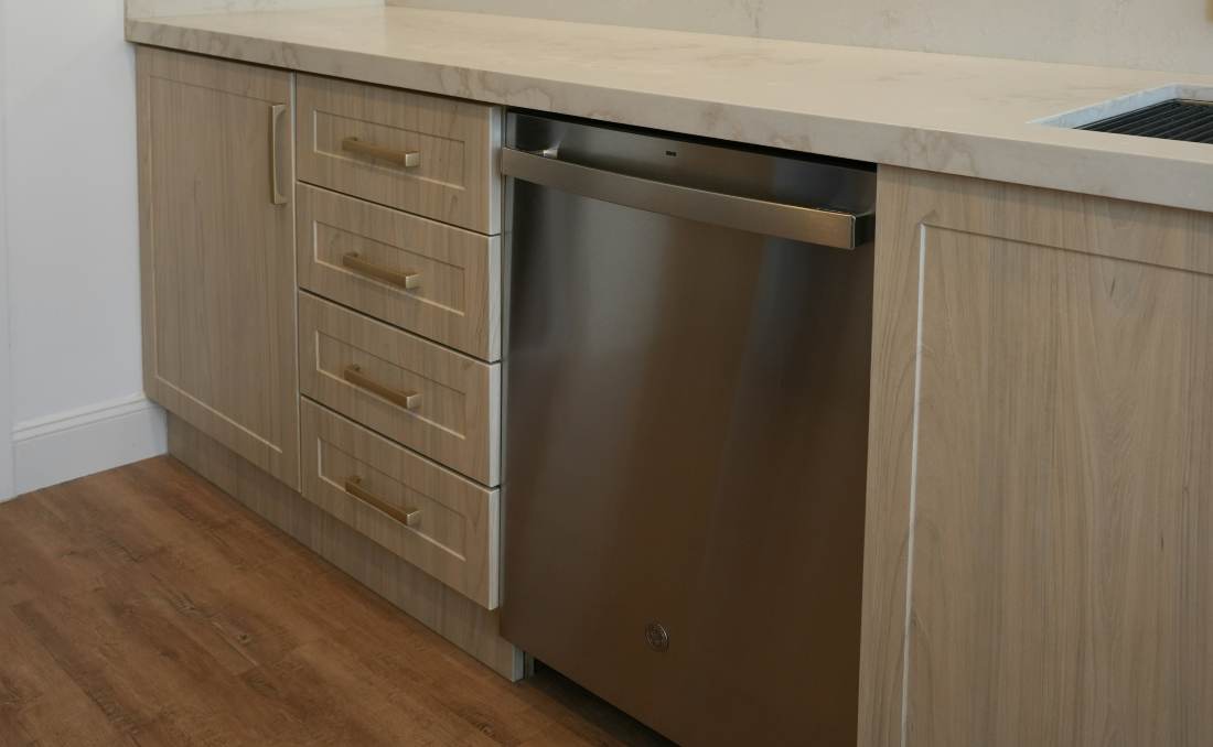 Ma&scaron;ina za sudove ugrađena u modernu kuhinju pored sudopere.