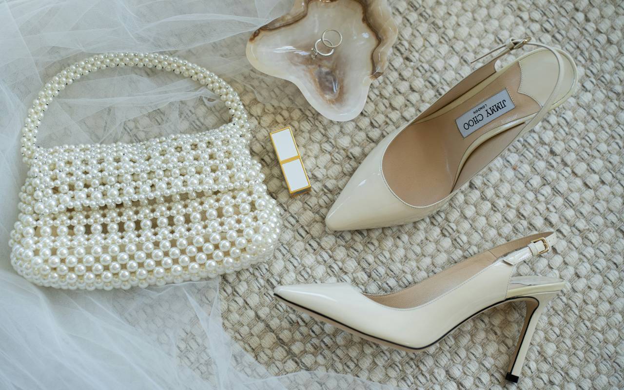 Bele slingback salonke i torbica položene na krevetu.